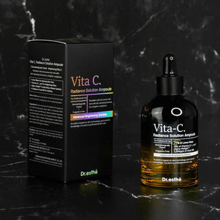 Dr. Esthe Vita-C skincare product packaging on a dark marble background