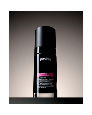 A black Pavise skincare bottle with a matching black cap, featuring white and pink text on a dark gradient background.