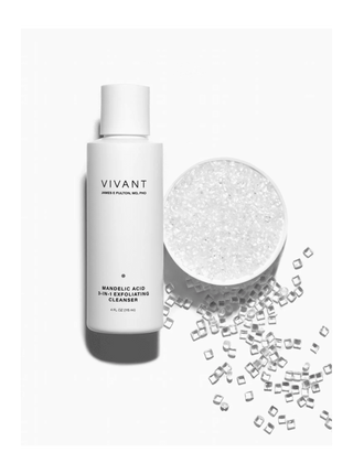 VIVANT Mandelic Acid 3-in-1 Exfoliating Cleanser bottle in white, shown next to a bowl of white exfoliating crystals with scattered clear crystal pieces on a white background.