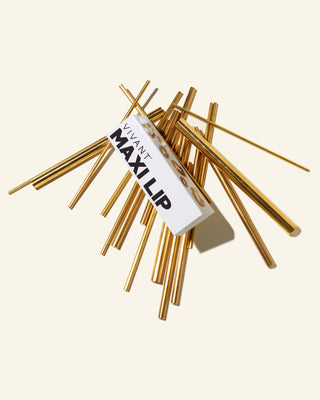 A bundle of Vivant Maxip Lip gold-plated metal extension rods with a white paper label, displayed on a solid cream background.