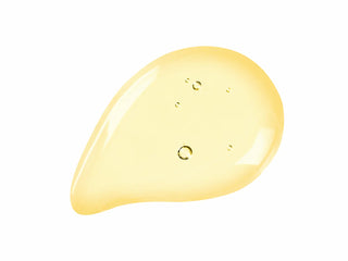 A glossy, teardrop-shaped droplet of pale yellow cosmetic serum or oil on a solid white background.