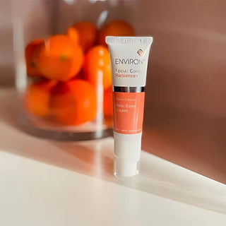 Environ Focus Care Radiance on table with oranges in background.